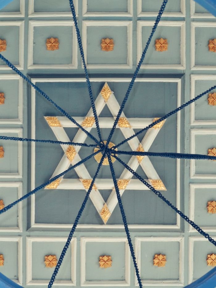 Symmetrical ceiling pattern featuring a central Star of David with geometric shapes and decorative elements.