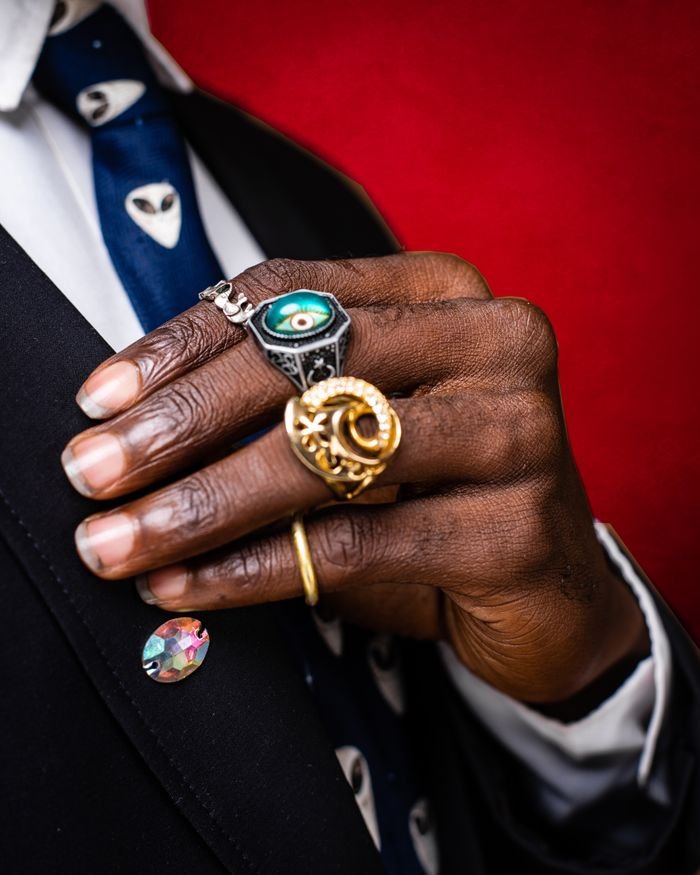 services-01 Close-up of hands with elegant rings beside a red textured background, showcasing style and fashion.