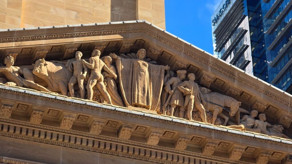 Close-up of detailed sculptures on a historical building facade under a clear blue sky.